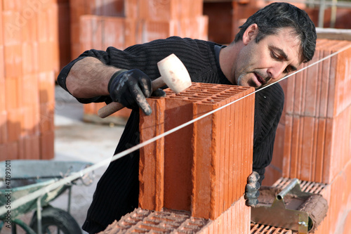 Photo: Man making sure wall is straight Man making sure wall is straight