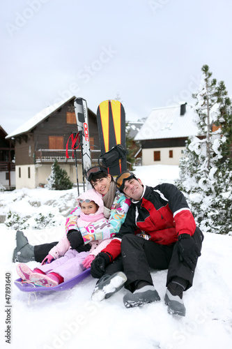 Photo: Family of skiers sat by chalet Family of skiers sat by chalet