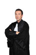 Man in graduation robes with arms folded