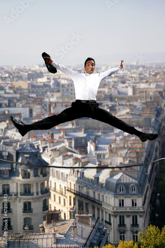 Photo: Businessman jumping for joy on a tightrope Businessman jumping for joy on a tightrope