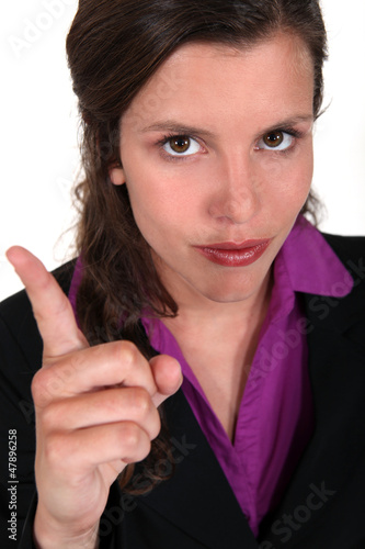 Photo: young businesswoman with her finger up young businesswoman with her finger up