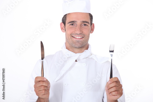 Photo: Chef in uniform holding a knife and fork Chef in uniform holding a knife and fork