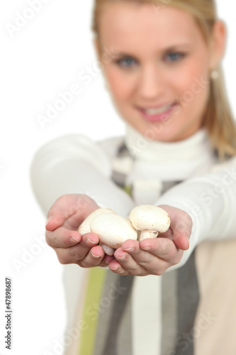 Photo: Blonde woman showing bunch of mushrooms Blonde woman showing bunch of mushrooms