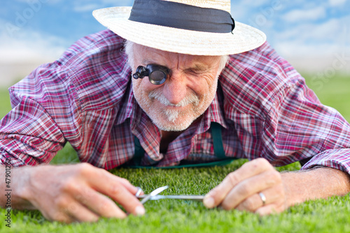 Photo: Close up of senior gardener cutting grass 4 Close up of senior gardener cutting grass 4