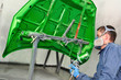 Worker painting a bonnet.