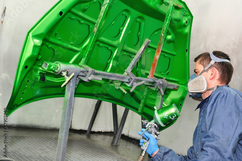 Photo: Worker painting a bonnet. Worker painting a bonnet.