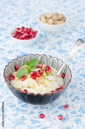 Photo: semolina dessert with pomegranate seeds and pistachios in a bowl semolina dessert with pomegranate seeds and pistachios in a bowl