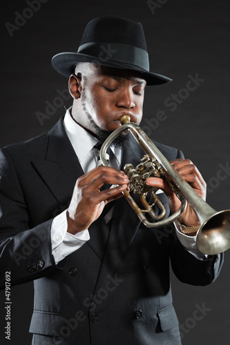 Photo: Black american jazz trumpet player. Vintage. Studio shot. Black american jazz trumpet player. Vintage. Studio shot.