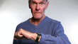 Angry senior man looking and pointing at his watch. Too late.
