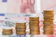 aufgebaute Stapel mit Euromünzen auf Banknoten