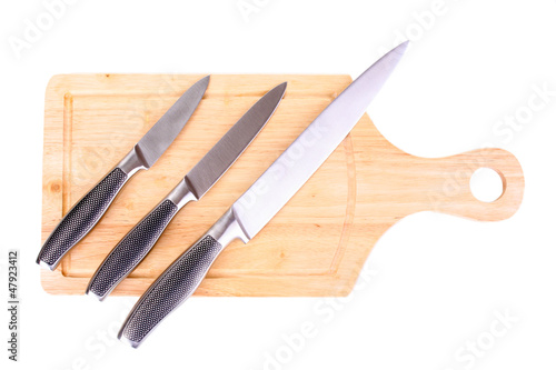 Photo: Set of knives on cutting board isolated on white Set of knives on cutting board isolated on white