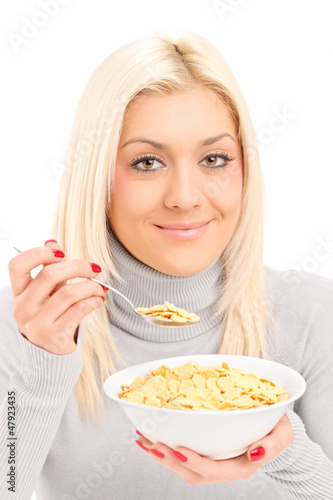 Photo: A blond female eating cornflakes at breakfast A blond female eating cornflakes at breakfast
