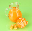 Full jug of tangerine juice, on wooden color  background