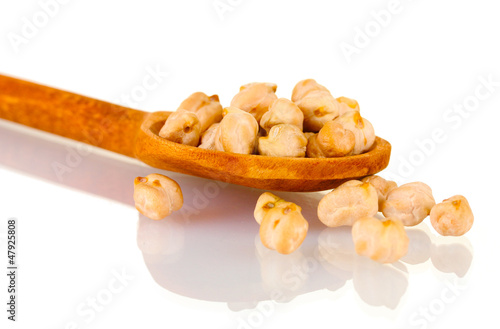 Photo: White chickpeas over wooden spoon isolated on white White chickpeas over wooden spoon isolated on white