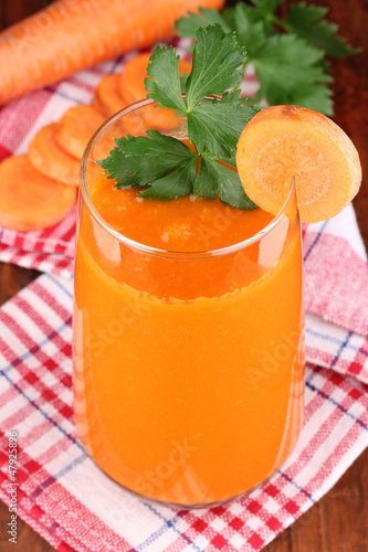 Photo: Glass of carrot juice on wooden table Glass of carrot juice on wooden table
