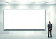 Business person standing near a blank billboard