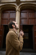 Man praying in church holding prayer beads