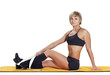 woman sitting down and stretching her legs on white background