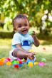 Little african american baby boy playing in the grass
