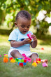 Little african american baby boy playing in the grass