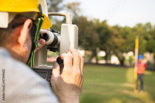 Photo: Surveyor engineer with partner making measure on the field Surveyor engineer with partner making measure on the field