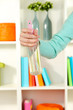 Sprayed air freshener in hand on white shelves background