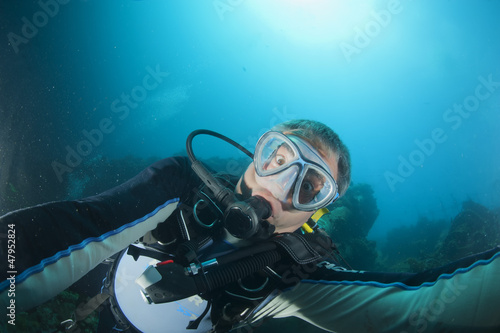 Photo: A scuba diver gone crazy try to open porthole from underwater A scuba diver gone crazy try to open porthole from underwater
