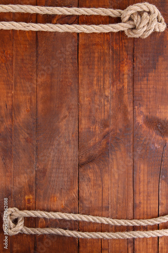 Photo: Frame composed of rope on wooden background Frame composed of rope on wooden background