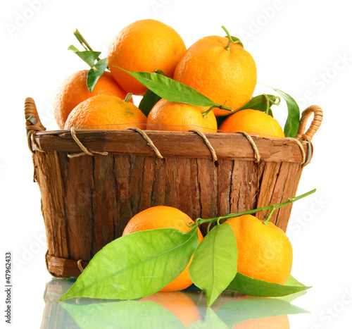 Photo: Ripe sweet tangerine with leaves in basket, isolated on white Ripe sweet tangerine with leaves in basket, isolated on white
