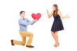Photo: Smiling male kneeling with red heart and surprised woman Smiling male kneeling with red heart and surprised woman