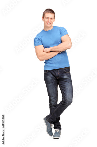 Photo: Full length portrait of a young man leaning on a wall Full length portrait of a young man leaning on a wall