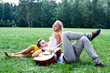 Photo: A young man plays guitar in the park beautiful woman A young man plays guitar in the park beautiful woman
