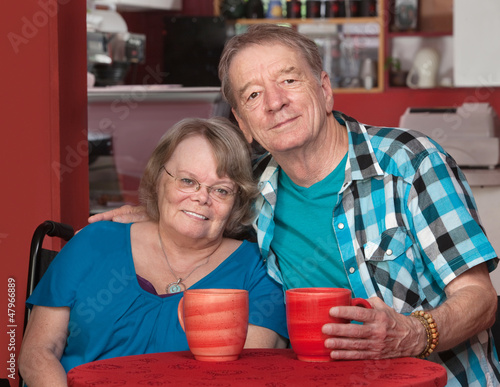 Photo: Smiling Senior Male and Female at Table Smiling Senior Male and Female at Table