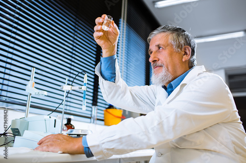 Photo: Senior male researcher carrying out scientific research in a lab Senior male researcher carrying out scientific research in a lab