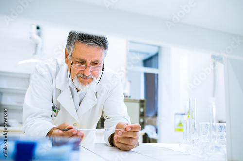 Photo: Senior male researcher carrying out scientific research in a lab Senior male researcher carrying out scientific research in a lab