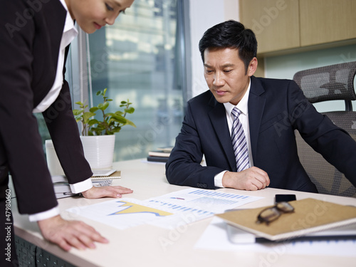 Photo: manager reviewing business with subordinate manager reviewing business with subordinate