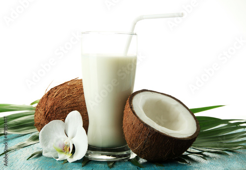 Photo: Coconuts with glass of milk, on blue wooden background Coconuts with glass of milk, on blue wooden background