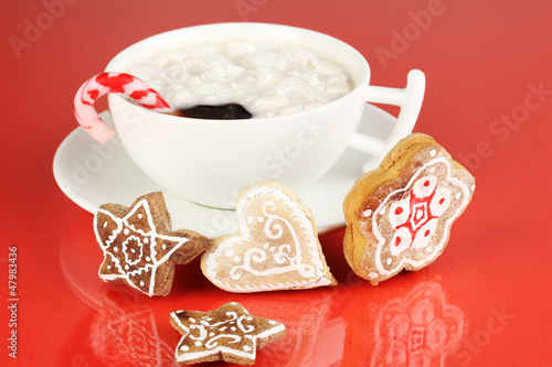 Photo: Cup of coffee with Christmas sweetness on red background Cup of coffee with Christmas sweetness on red background