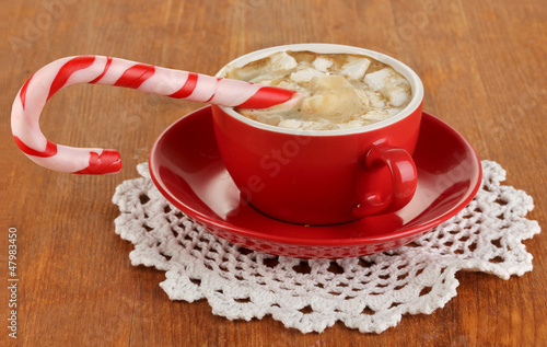 Photo: Cup of coffee with holiday candy on wooden table close-up Cup of coffee with holiday candy on wooden table close-up