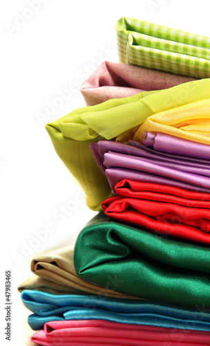Photo: heap of cloth fabrics on wooden table heap of cloth fabrics on wooden table