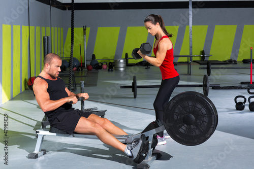 Photo: Gym couple with dumbbell weights and fitness rower Gym couple with dumbbell weights and fitness rower