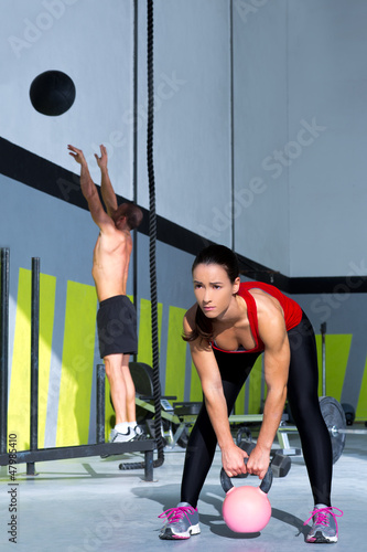 Photo: Crossfit gym Kettlebell woman and wall ball man Crossfit gym Kettlebell woman and wall ball man