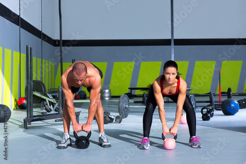 Photo: Kettlebells swing crossfit exercise man and woman Kettlebells swing crossfit exercise man and woman