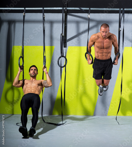 Photo: Crossfit dip ring two men workout at gym dipping Crossfit dip ring two men workout at gym dipping