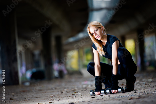 Photo: Woman lifting weights in urban setting Woman lifting weights in urban setting