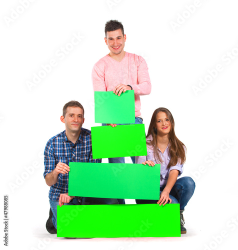 Photo: Group of people holding green tree shaped papers Group of people holding green tree shaped papers