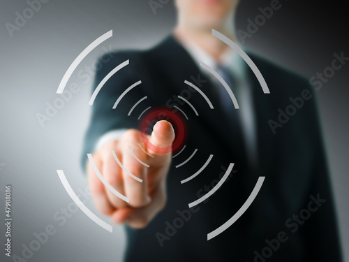 Photo: Businessman pointing at camera with digital elements Businessman pointing at camera with digital elements