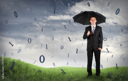 Photo: Businessman on a field with binary code falling Businessman on a field with binary code falling