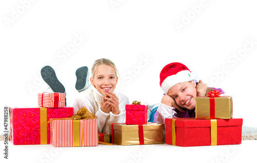 Photo: Two cute girls with a lot of presents over a white background Two cute girls with a lot of presents over a white background