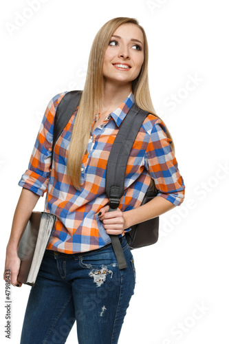 Photo: Smiling university student standing with backpack holding folder Smiling university student standing with backpack holding folder